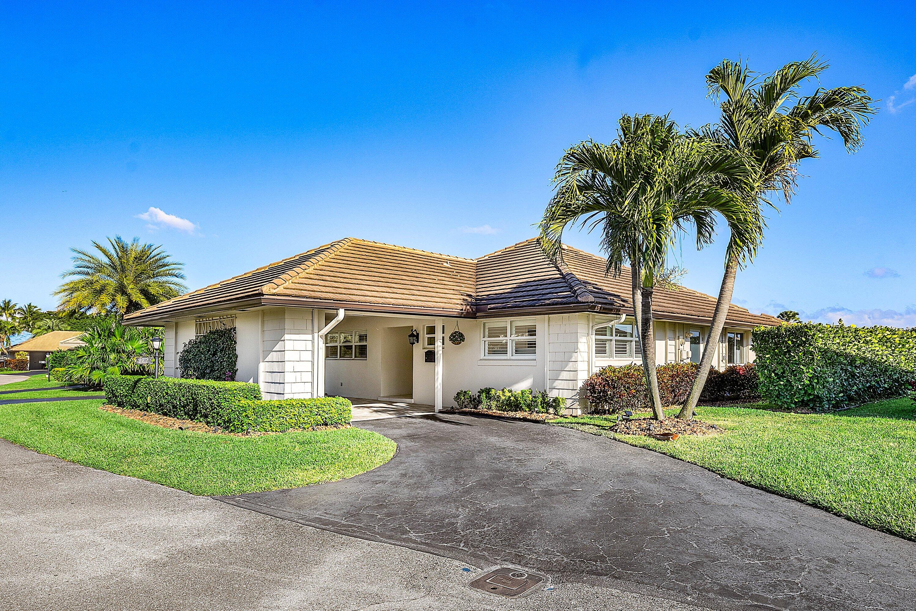322 Cedar Key Circle Atlantis, FL 33462 - Photo 2 of 55 a view of a house with a big yard and palm trees