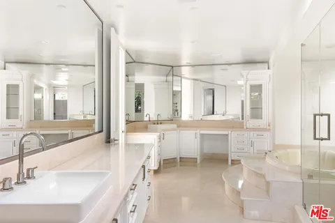 a large bathroom with a double vanity sink mirror and a bath