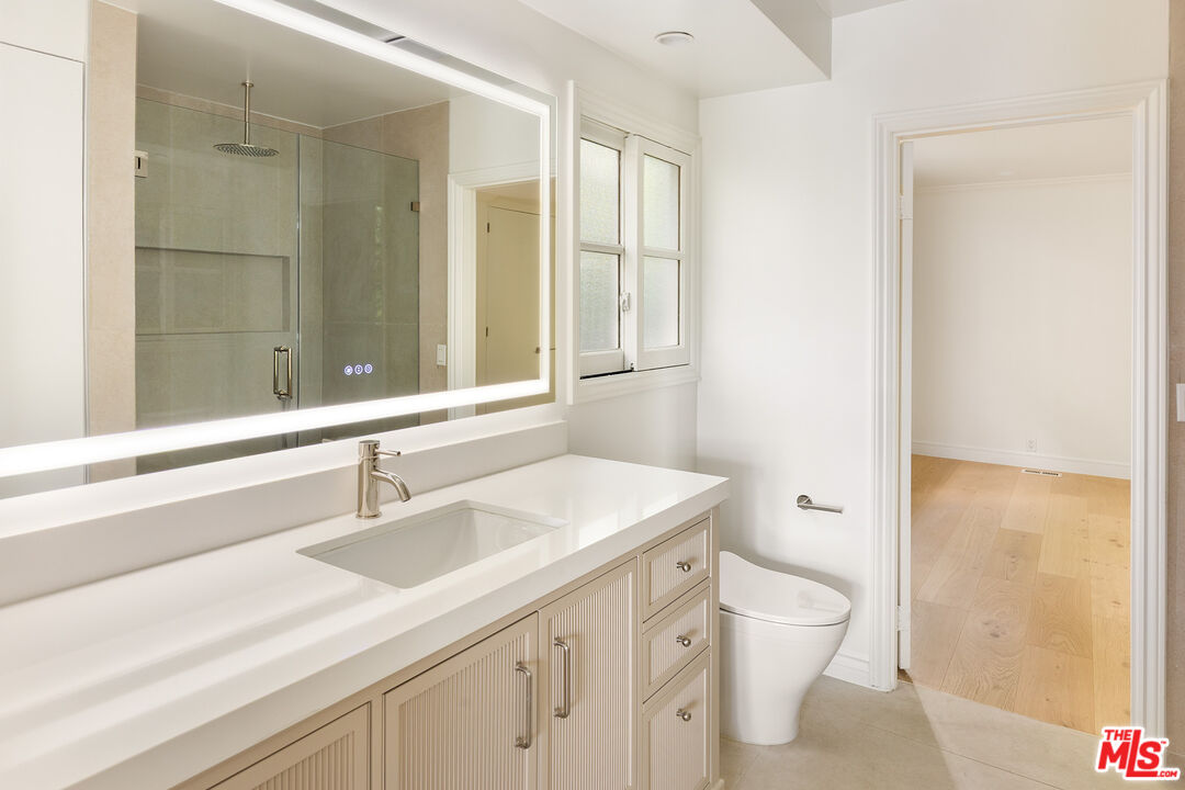 1630 Carla Ridge Beverly Hills, CA 90210 - Photo 13 of 22 a bathroom with a sink a toilet a large mirror and shower
