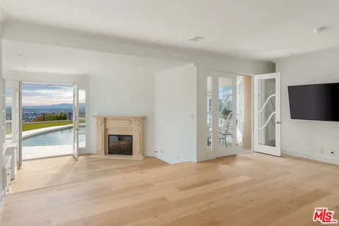 an empty room with fireplace and fan