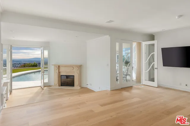 an empty room with fireplace and fan