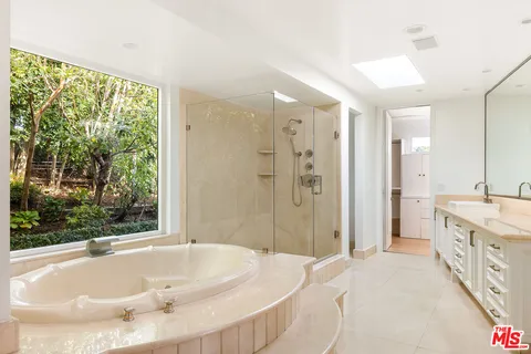 a spacious bathroom with a tub sink and shower