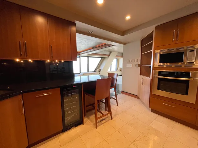 a kitchen with stainless steel appliances kitchen island granite countertop a sink and a refrigerator