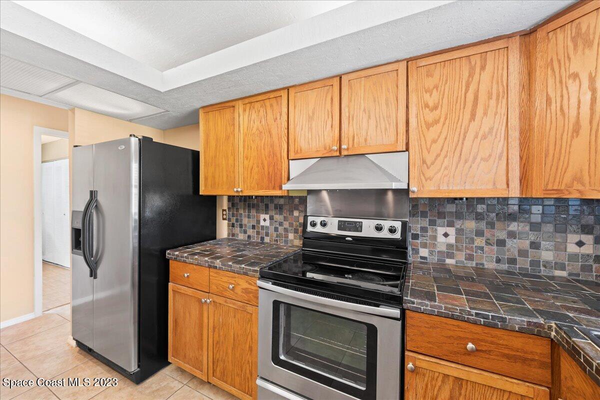 1379 Cromey Road Northeast Palm Bay, FL 32905 - Photo 11 of 25 a kitchen with stainless steel appliances granite countertop a stove a refrigerator and a sink