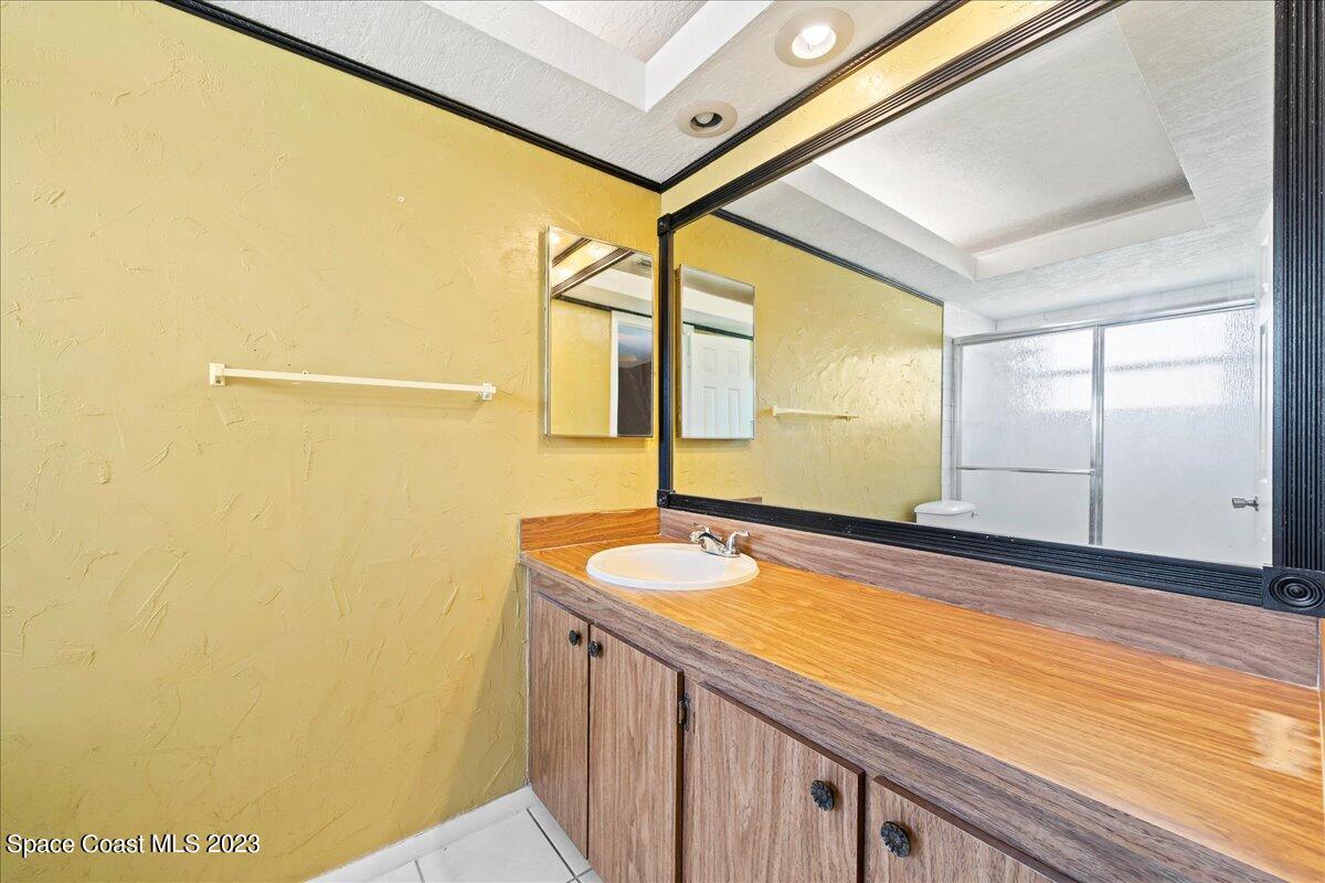 1379 Cromey Road Northeast Palm Bay, FL 32905 - Photo 13 of 25 a bathroom with a granite countertop sink and a large mirror