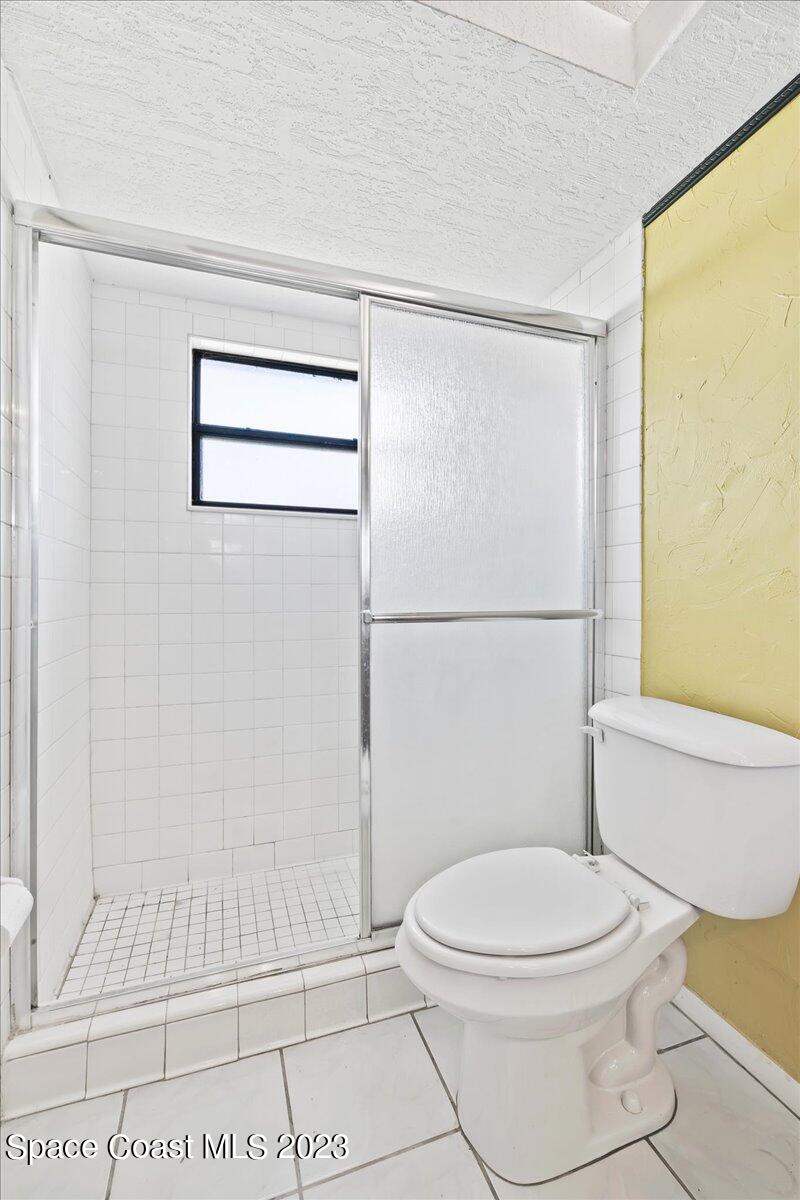 1379 Cromey Road Northeast Palm Bay, FL 32905 - Photo 14 of 25 a white toilet sitting next to a bath tub and a shower
