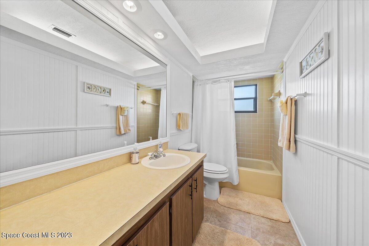1379 Cromey Road Northeast Palm Bay, FL 32905 - Photo 17 of 25 a bathroom with a sink a mirror and a bathtub