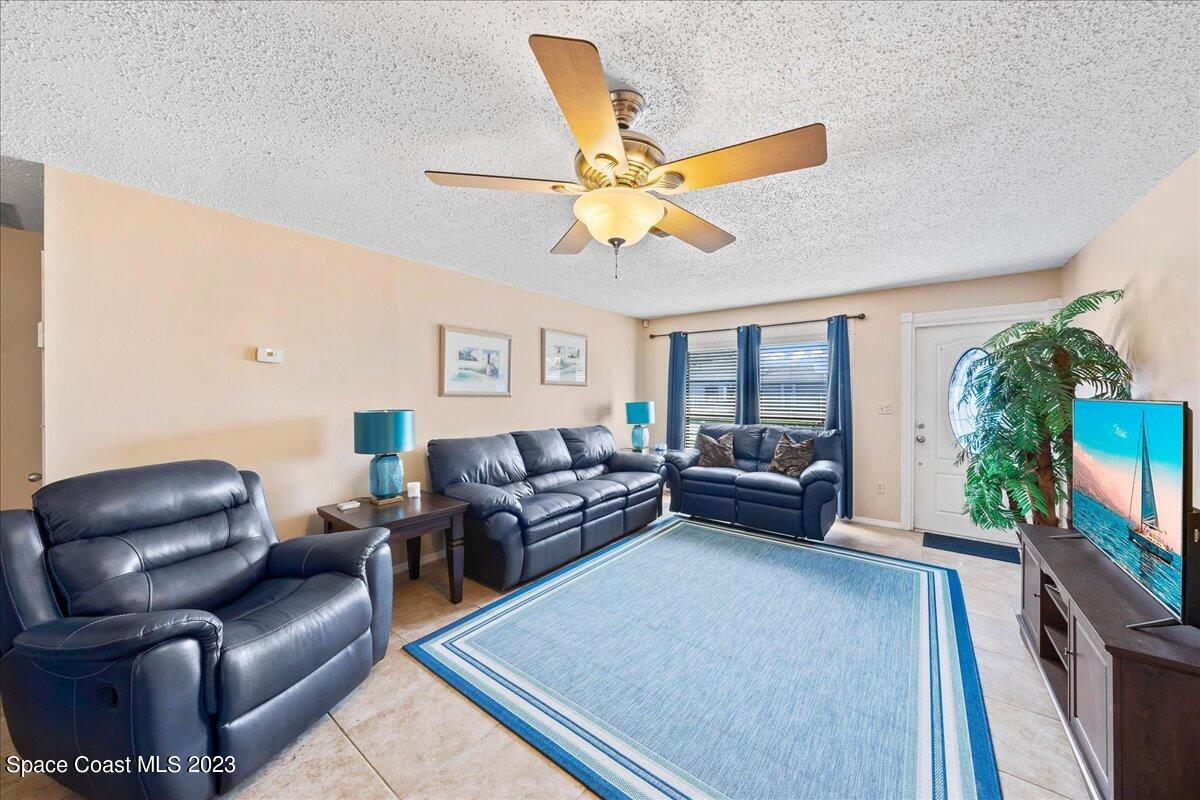 1379 Cromey Road Northeast Palm Bay, FL 32905 - Photo 5 of 25 a living room with furniture and a flat screen tv