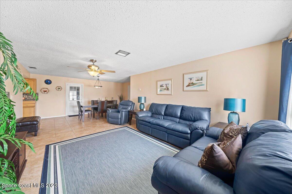 1379 Cromey Road Northeast Palm Bay, FL 32905 - Photo 6 of 25 a living room with furniture and a flat screen tv