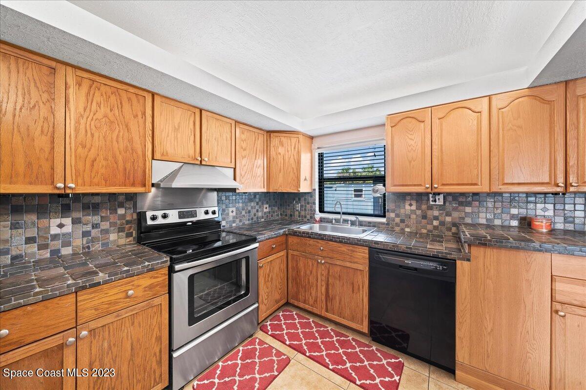 1379 Cromey Road Northeast Palm Bay, FL 32905 - Photo 9 of 25 a kitchen with granite countertop a sink stainless steel appliances and cabinets