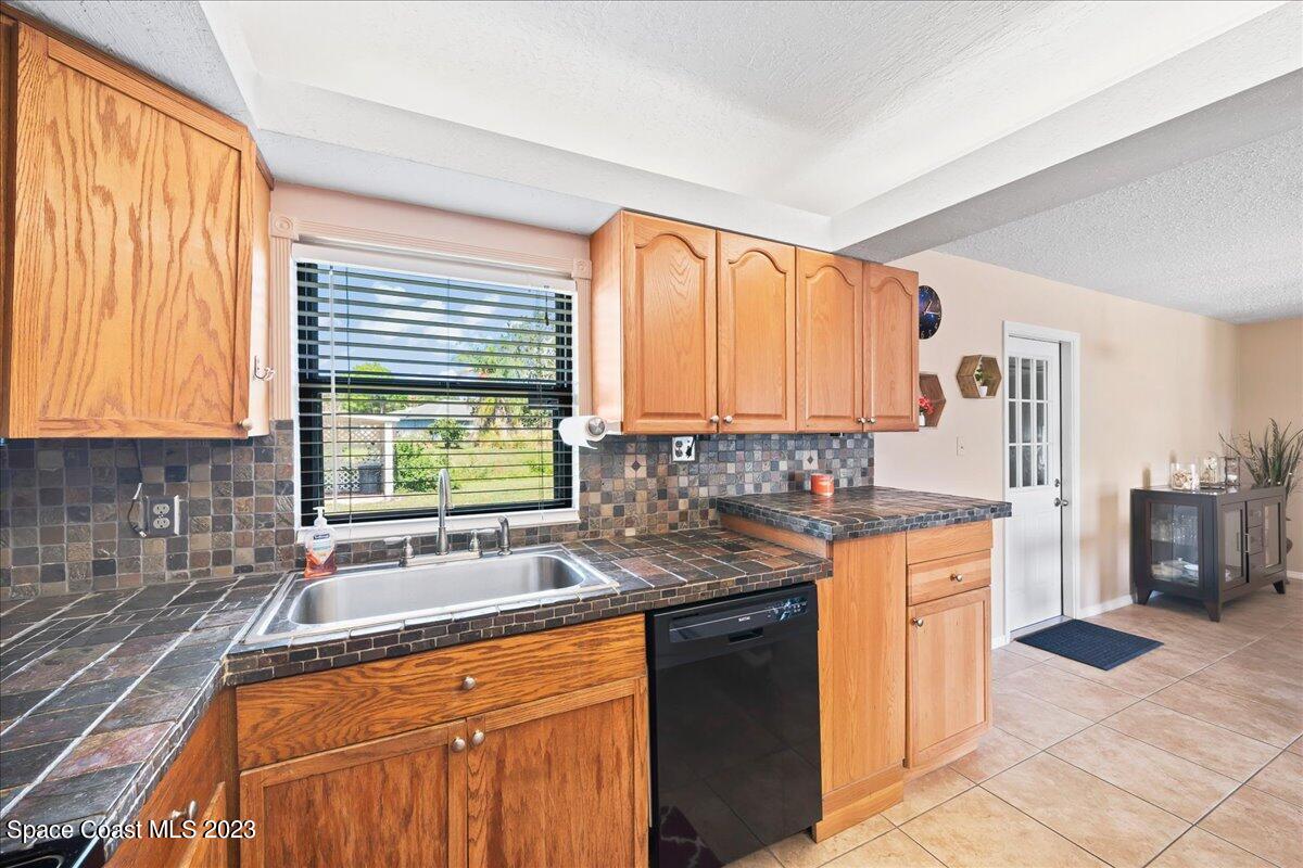 1379 Cromey Road Northeast Palm Bay, FL 32905 - Photo 10 of 25 a kitchen with stainless steel appliances granite countertop a sink stove and cabinets