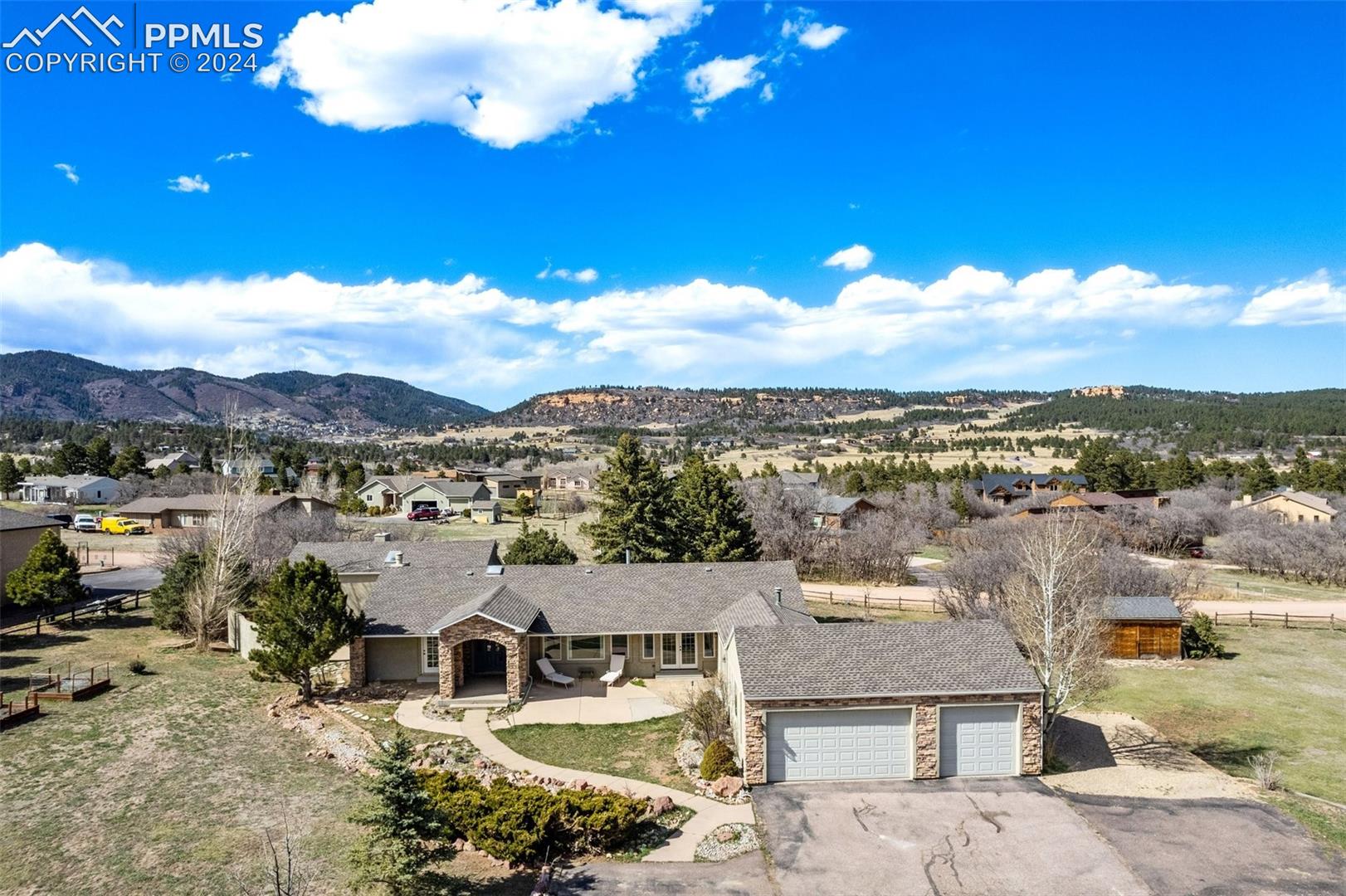 3830 Range View Road Monument, CO 80132 - Photo 2 of 50 Aerial view of home showing three car garage and five additional parking spaces. Two are on the left by the tree and three are on the right