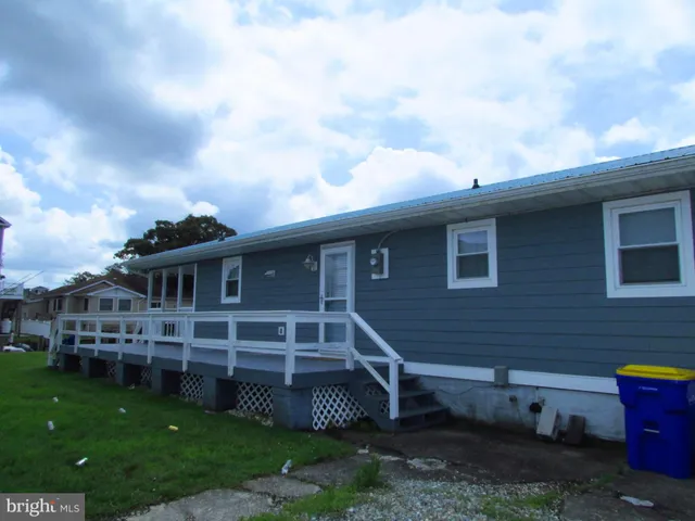 a view of a house with a yard plants and large tree