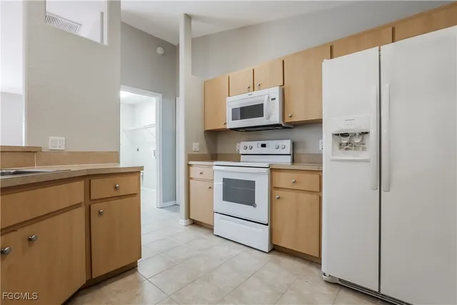 a kitchen with white cabinets and white appliances