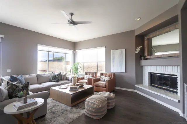 a living room with furniture a fireplace and a large window