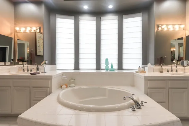 a bathroom with a tub sink and mirror