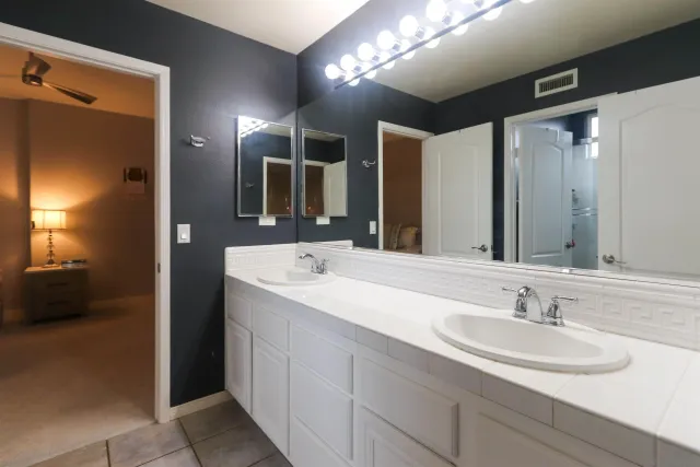 a bathroom with a double vanity sink and a mirror