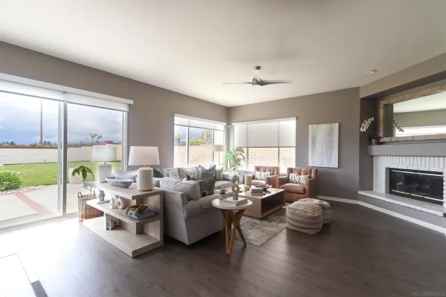 a living room with furniture and a fireplace with wooden floor