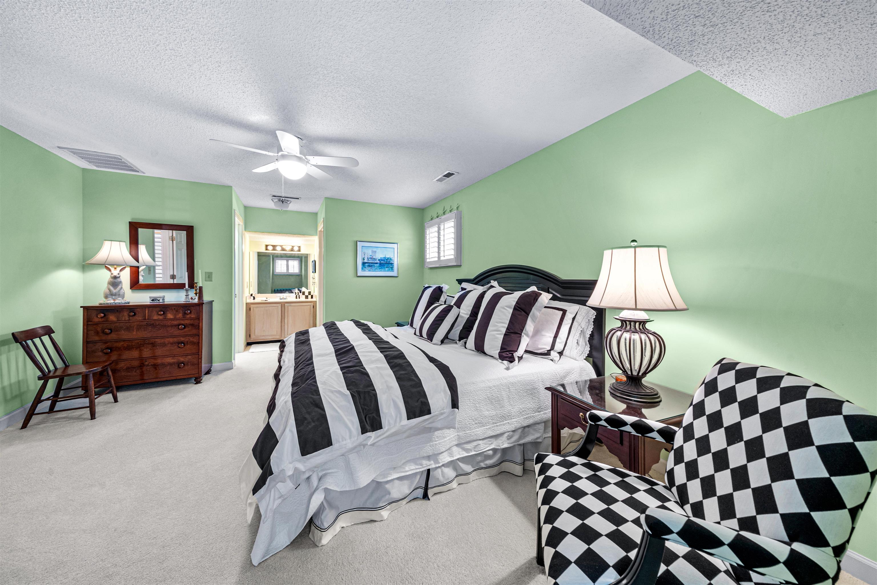 4801 Lightkeepers Way, Unit 17C Little River, SC 29566 - Photo 36 of 40 Bedroom with ensuite bathroom, a textured ceiling, carpet floors, and ceiling fan