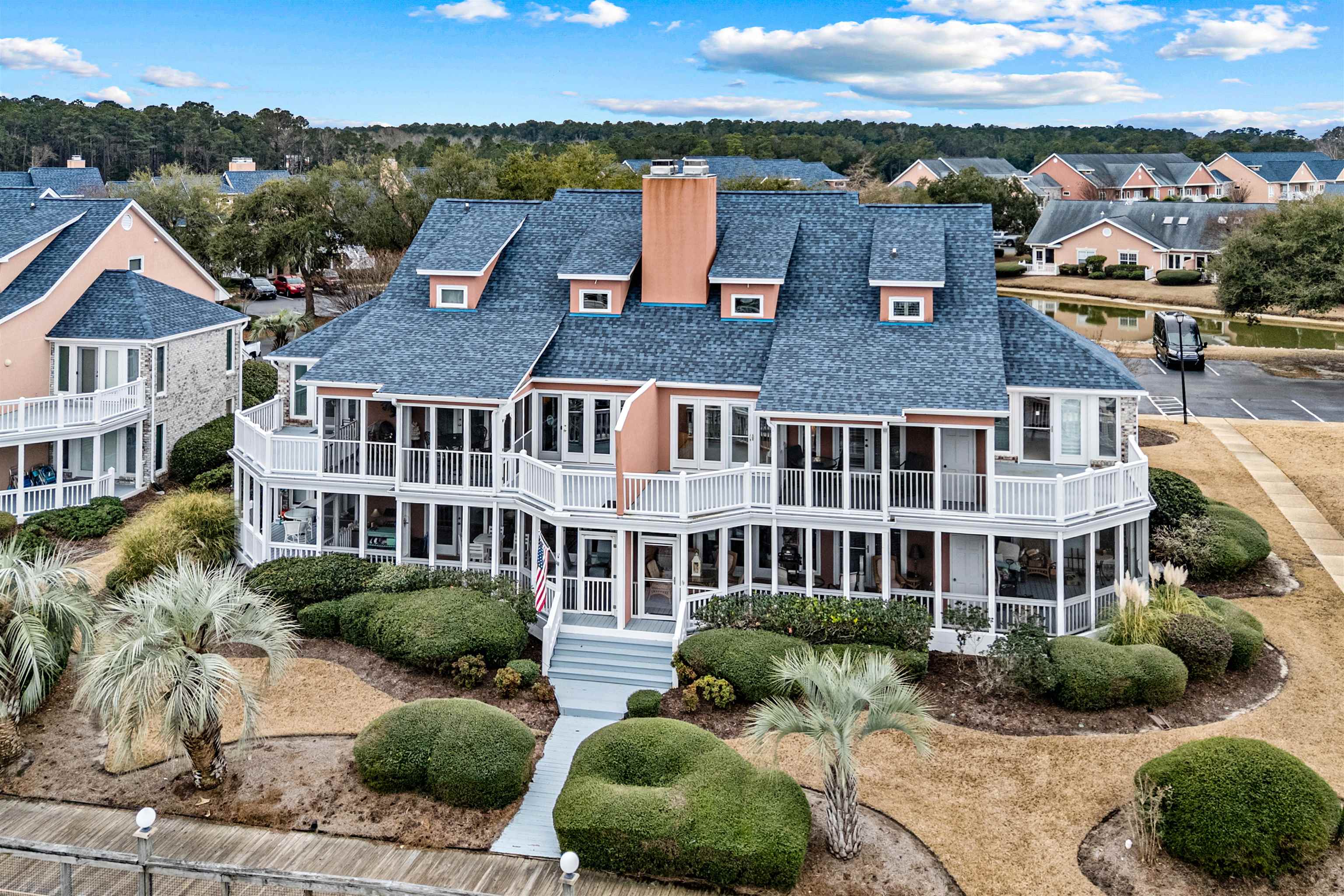 4801 Lightkeepers Way, Unit 17C Little River, SC 29566 - Photo 5 of 40 Back of property featuring a chimney, a shingled roof, and a porch