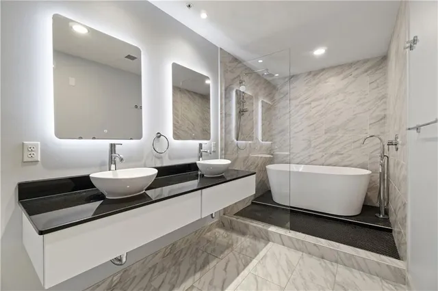 a bathroom with a large tub sink and vanity