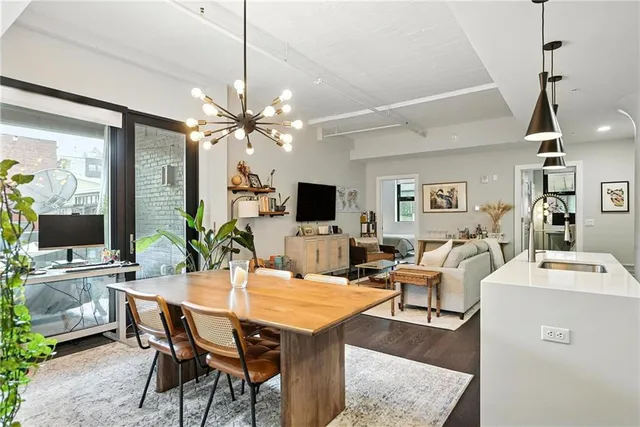 a view of a dining room with furniture and a chandelier fan