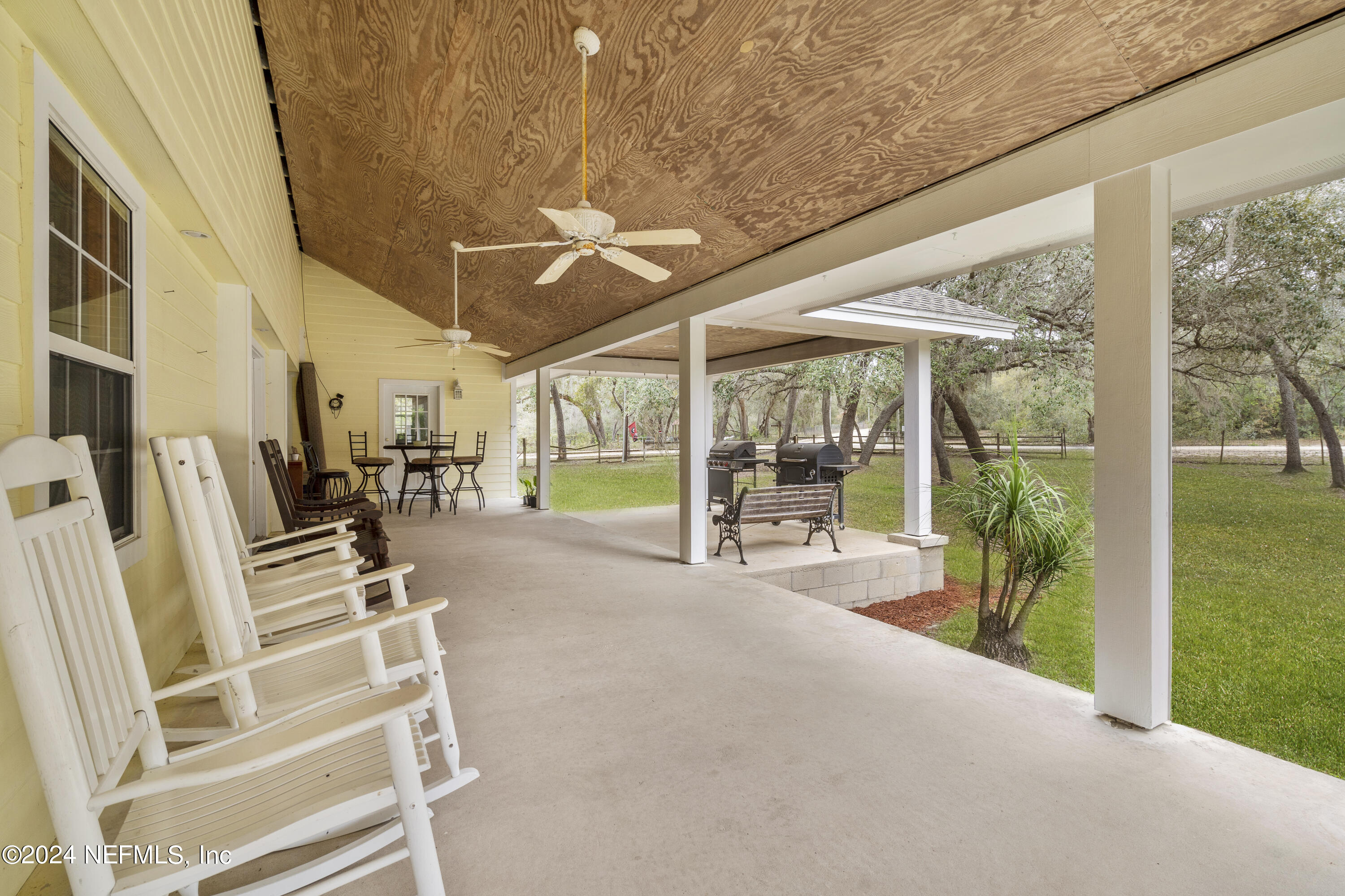 101 Tiffany Road Melrose, FL 32666 - Photo 28 of 51 a view of a patio with table and chairs under an umbrella with a large tree