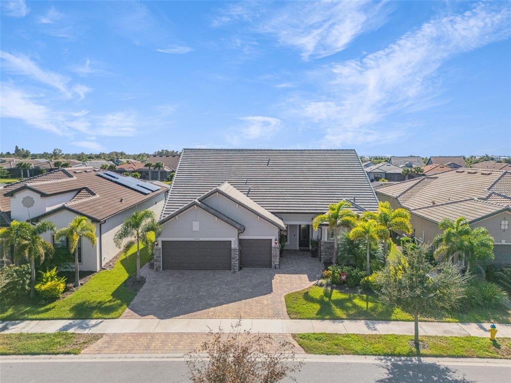 13303 Rinella Street Venice, FL 34293 - Photo 3 of 52 a view of a house with a yard and table and chairs under an umbrella