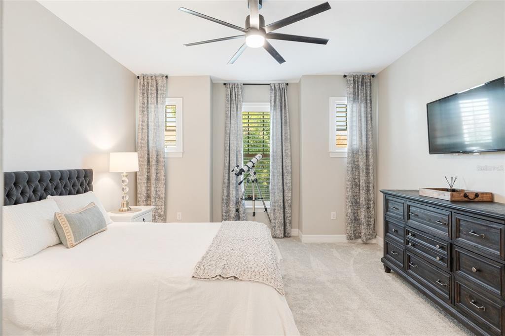 13303 Rinella Street Venice, FL 34293 - Photo 8 of 52 a bedroom with a large bed and a flat tv screen on dresser