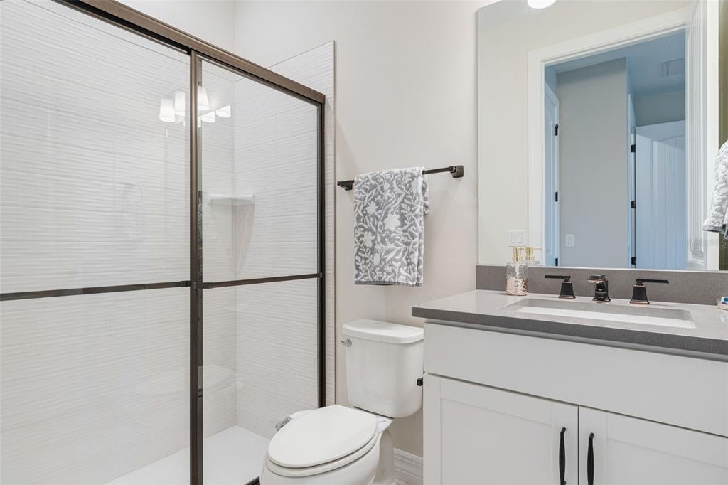 13303 Rinella Street Venice, FL 34293 - Photo 9 of 52 a bathroom with a sink a toilet a mirror and shower