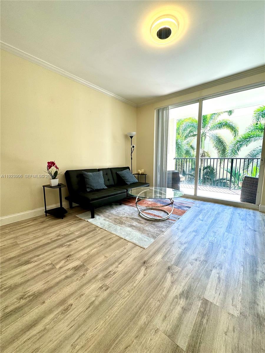 17150 North Bay Road, Unit 2419 Sunny Isles Beach, FL 33160 - Photo 1 of 12 a living room with a large window and a wooden floor