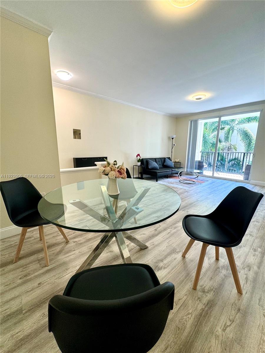 17150 North Bay Road, Unit 2419 Sunny Isles Beach, FL 33160 - Photo 2 of 12 a table and chairs in a dining room with wooden floor