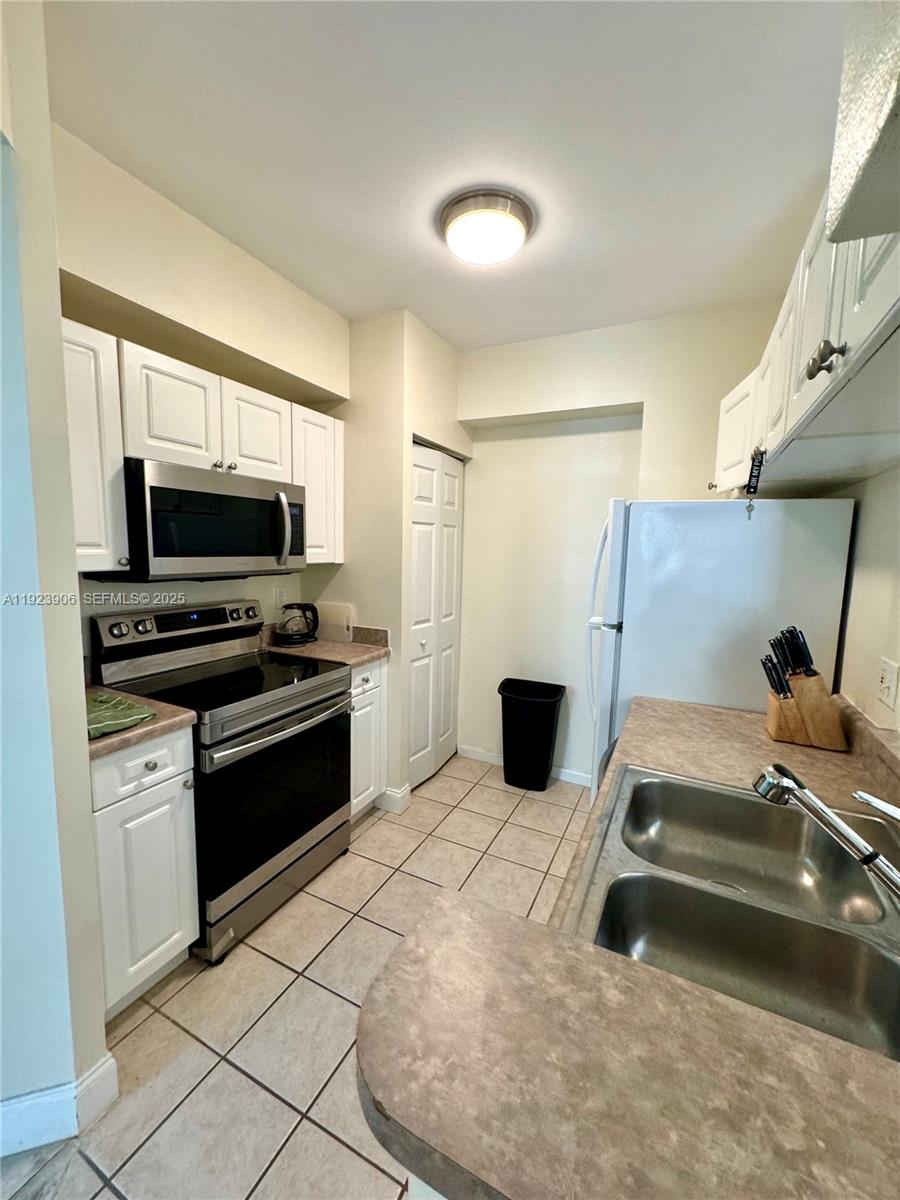 17150 North Bay Road, Unit 2419 Sunny Isles Beach, FL 33160 - Photo 6 of 12 a kitchen with stainless steel appliances a stove a microwave and a refrigerator