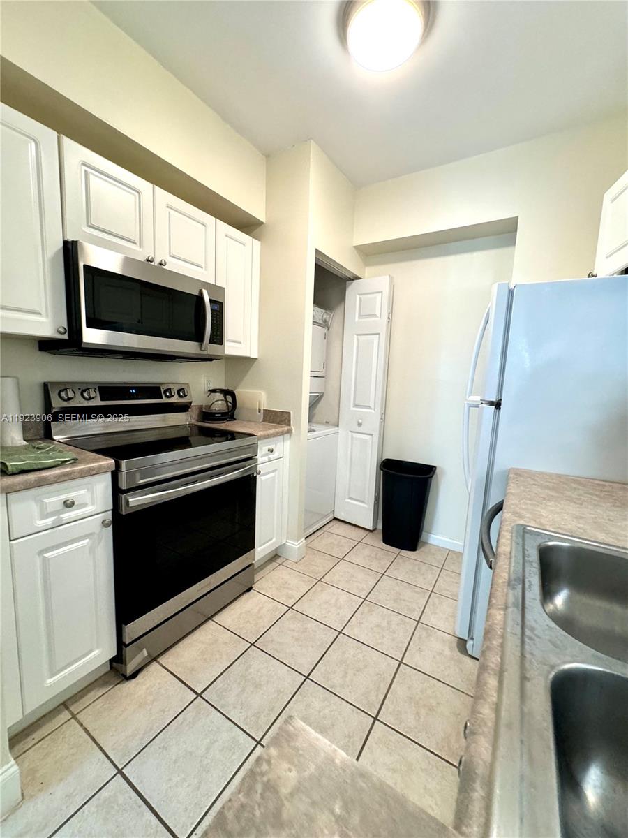 17150 North Bay Road, Unit 2419 Sunny Isles Beach, FL 33160 - Photo 8 of 12 a kitchen with a stove a microwave and a sink