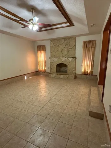 a view of an empty room with a fireplace and a window