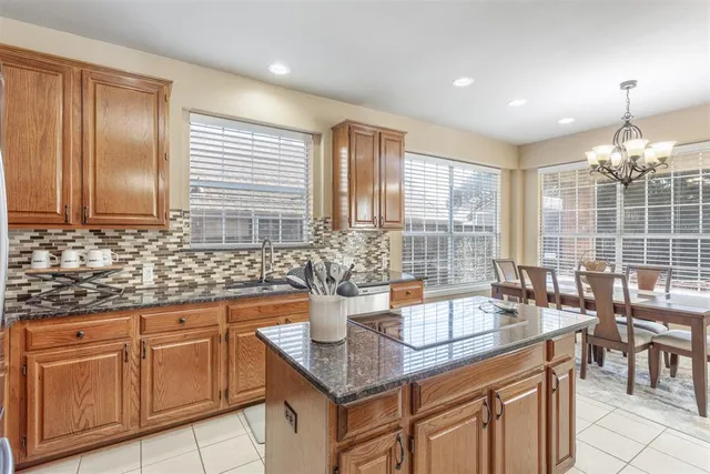 a kitchen with granite countertop a sink and white cabinets