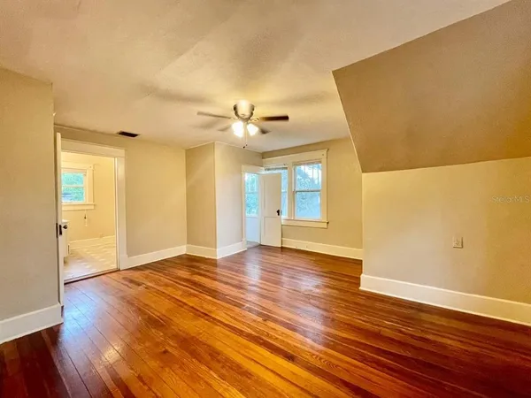 a view of an empty room with wooden floor