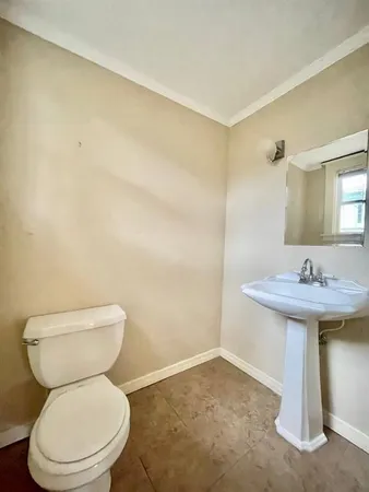 a bathroom with a sink a toilet and a mirror