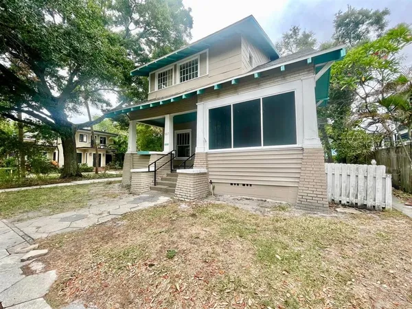 a view of a house with a yard and fence