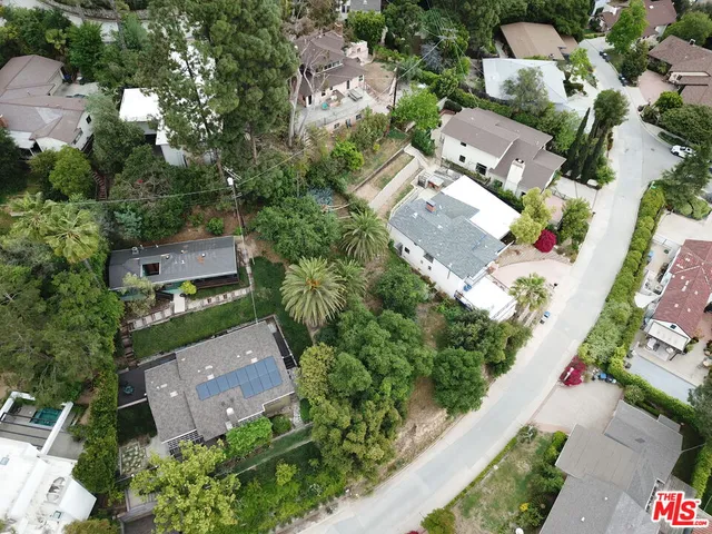 an aerial view of residential house with outdoor space and trees all around