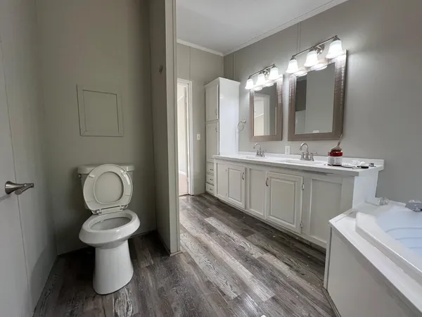 a bathroom with a toilet sink and mirror