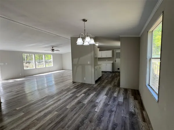 a view of a room with wooden floor window and kitchen view