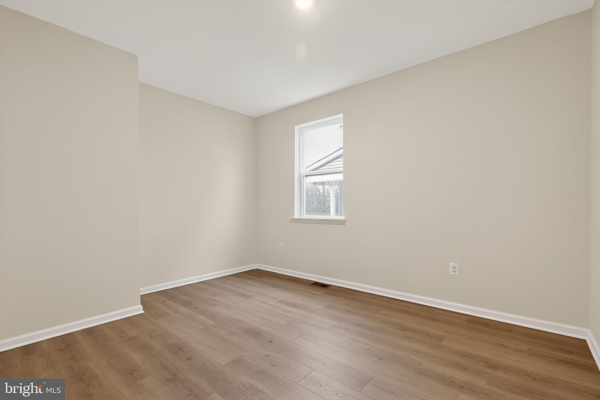 25020 Cypress Court Lewes, DE 19958 - Photo 15 of 21 an empty room with wooden floor and windows