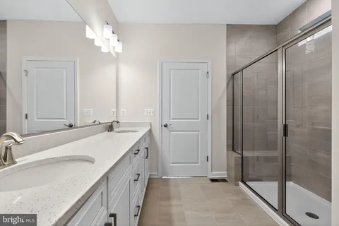 a bathroom with a double vanity sink mirror and shower