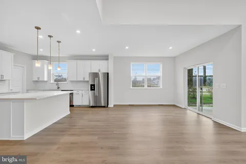 a large kitchen with stainless steel appliances kitchen island a large counter top and wooden floors
