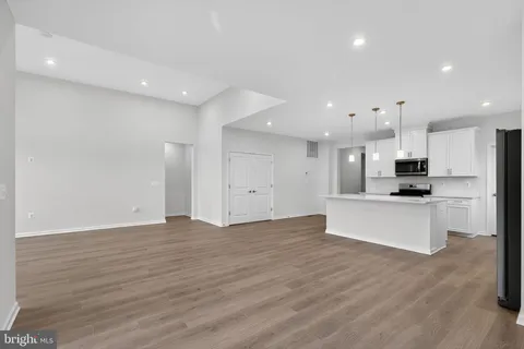 a large kitchen with stainless steel appliances kitchen island a large counter top and a stove top oven