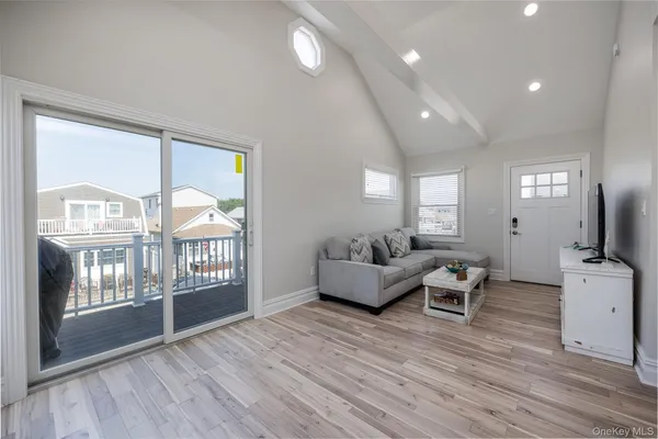 a living room with furniture a chandelier and wooden floor