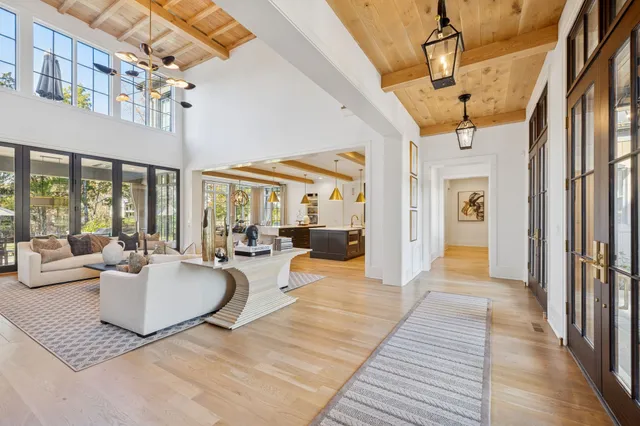 a large kitchen with kitchen island a large counter space a large window and stainless steel appliances