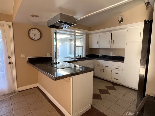 a kitchen with granite countertop a sink cabinets and stainless steel appliances