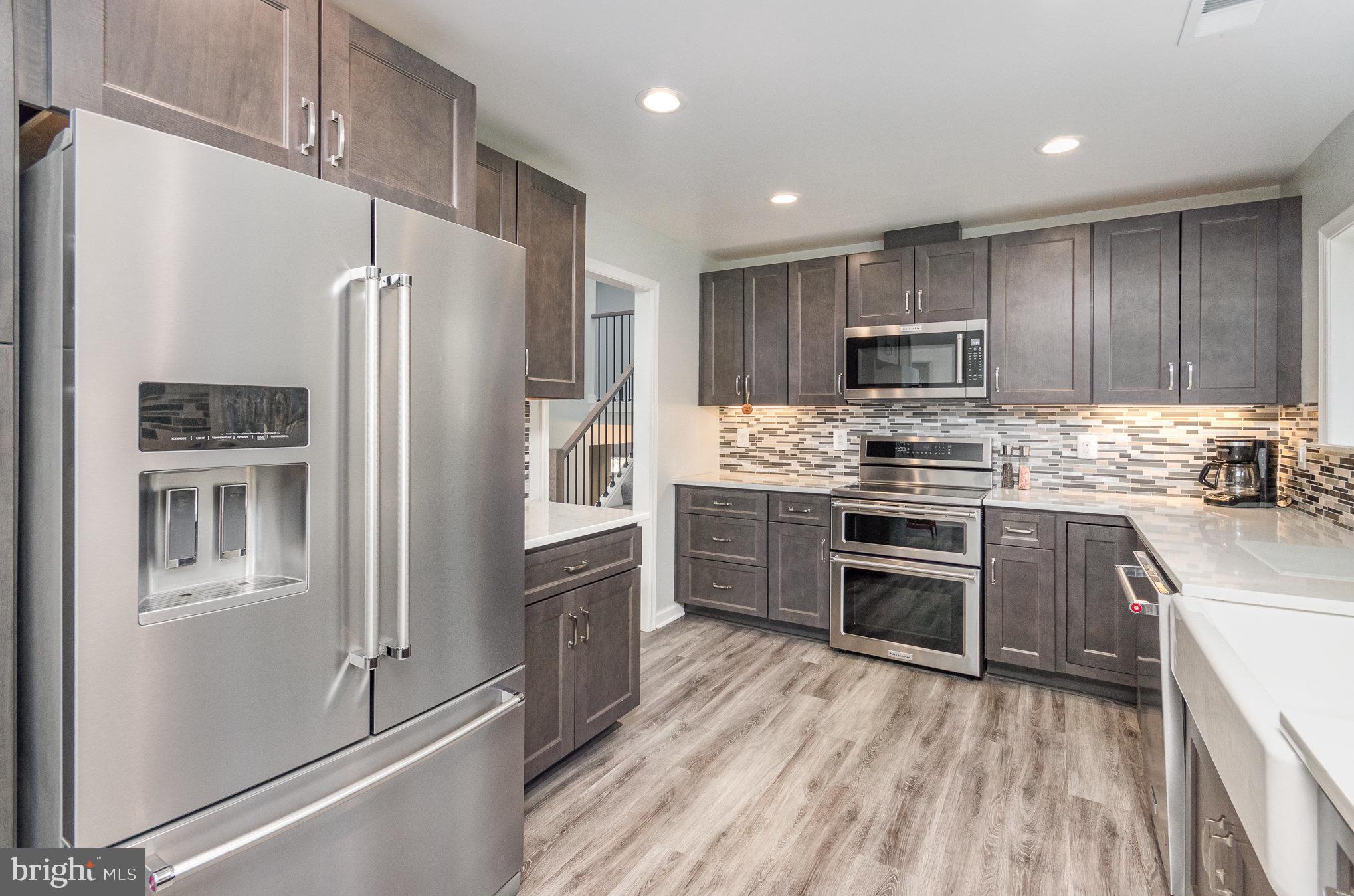 6932 Spelman Drive Springfield, VA 22153 - Photo 14 of 37 a kitchen with kitchen island a refrigerator stove and kitchen island